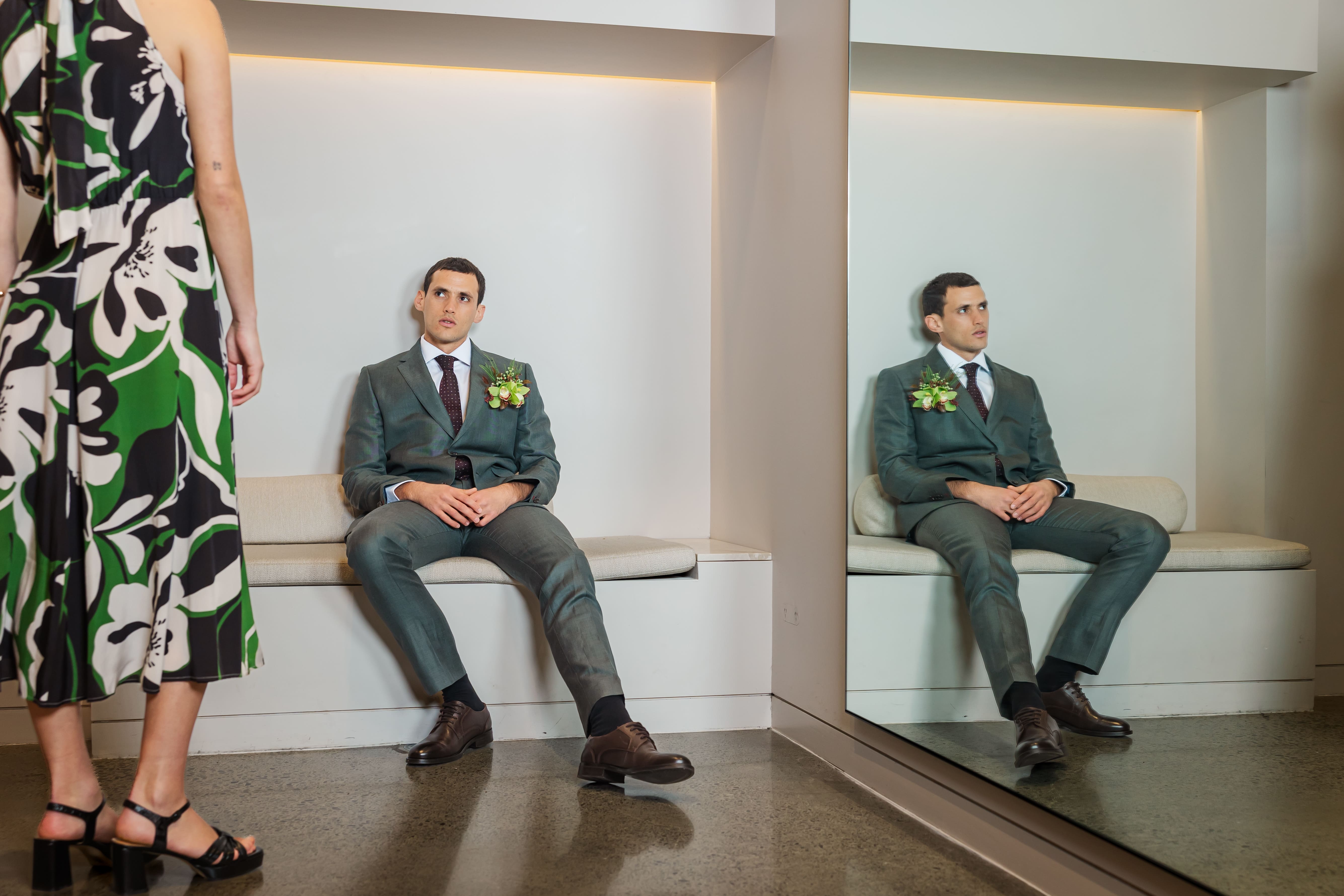 Boyfriend Seat. Juan waits patiently in the Juliette Hogan fitting room wearing a Bakers suit, shirt, tie, pants and dress shoes. Natural boutonniere by Thoisle & Co.